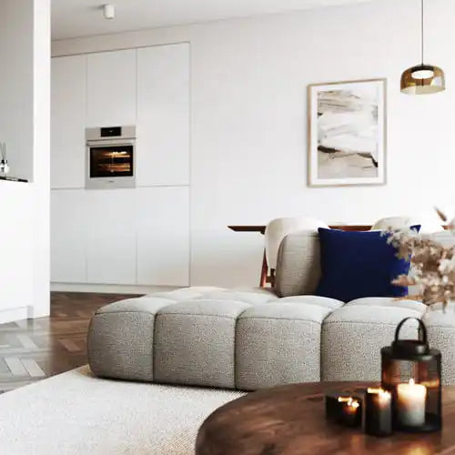 Hellgraues modulsofa mit getupften kissen.