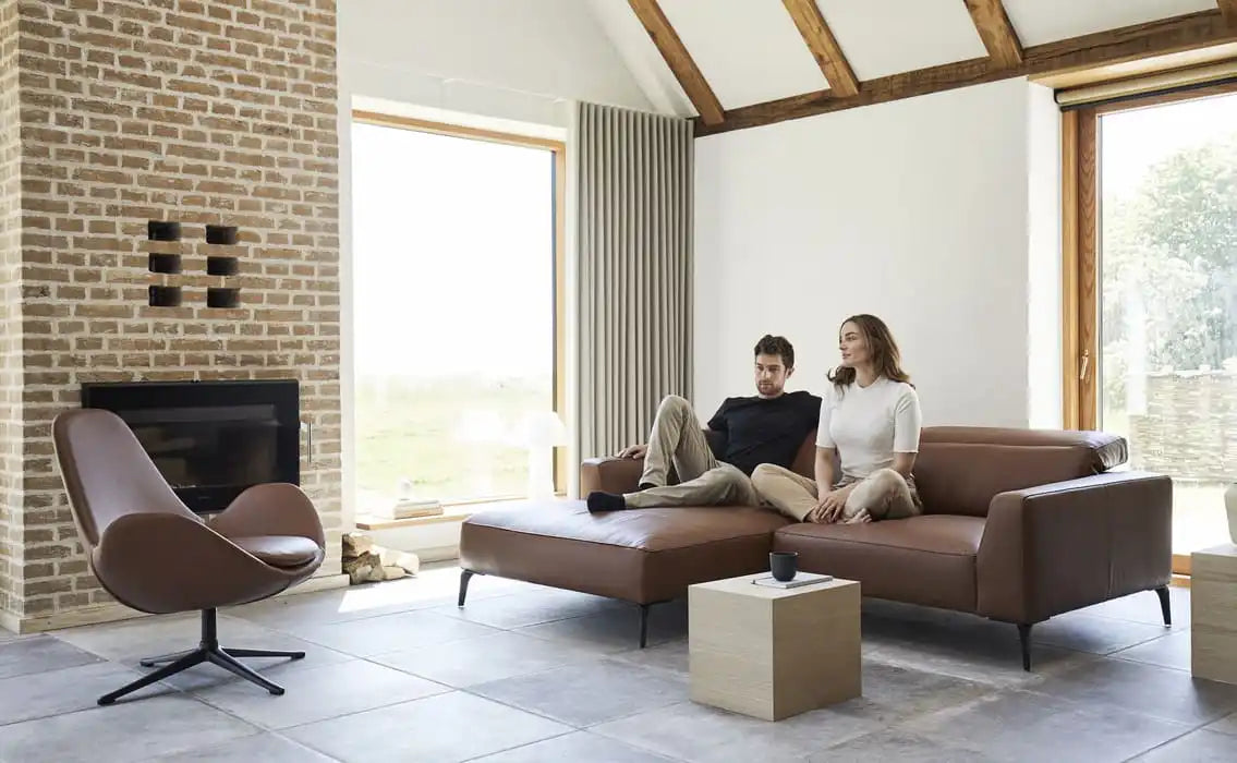 Ein braunes Ledersofa mit schwarzen Metallbeinen.