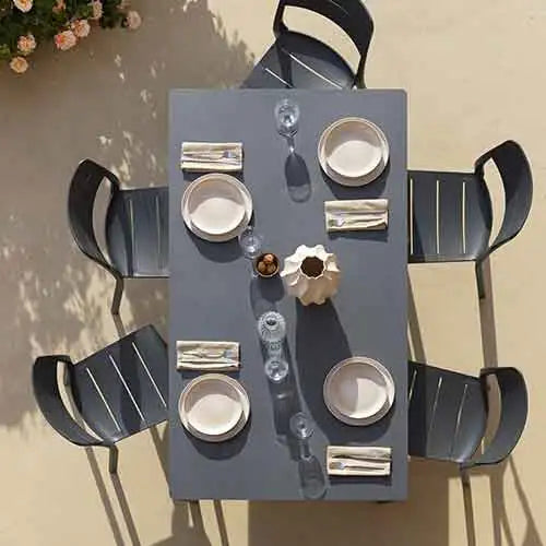 Graues Outdoor-Esszimmer-Set mit modernem Design und schwarzen Stühlen.