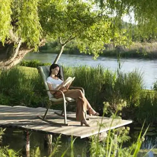 Holzrockerstuhl mit gepolsteter Sitzfläche und Rückenlehne, hellbraune Oberfläche.