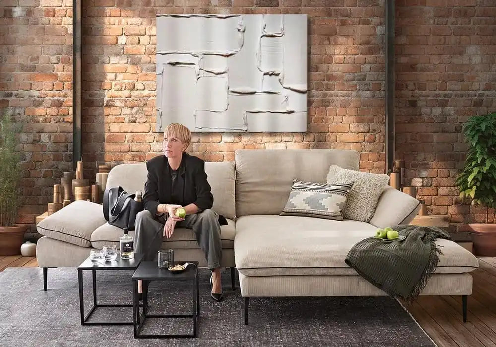 Ein modernes, modulares Chaisecouchtisch in einem neutralen Ton.